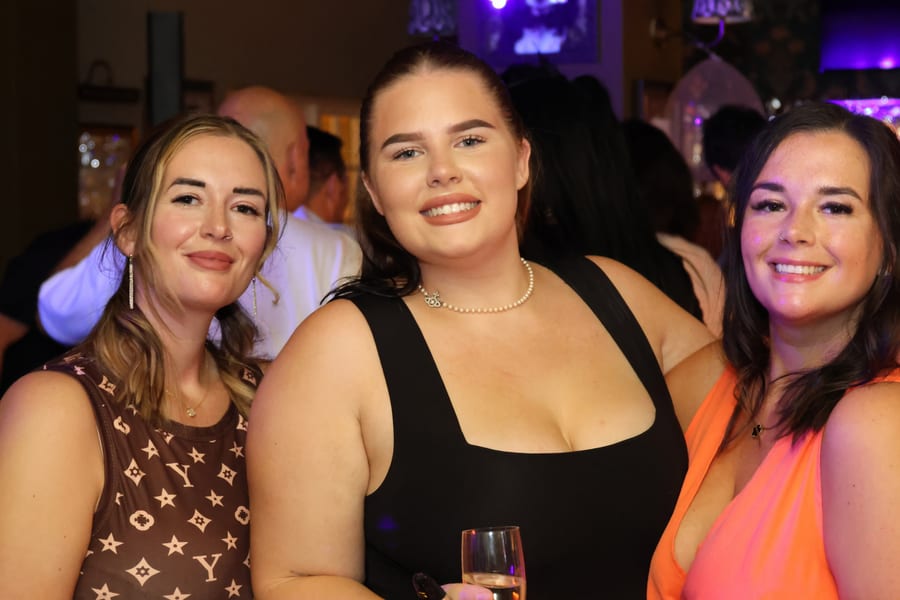 Three women smiling at a party