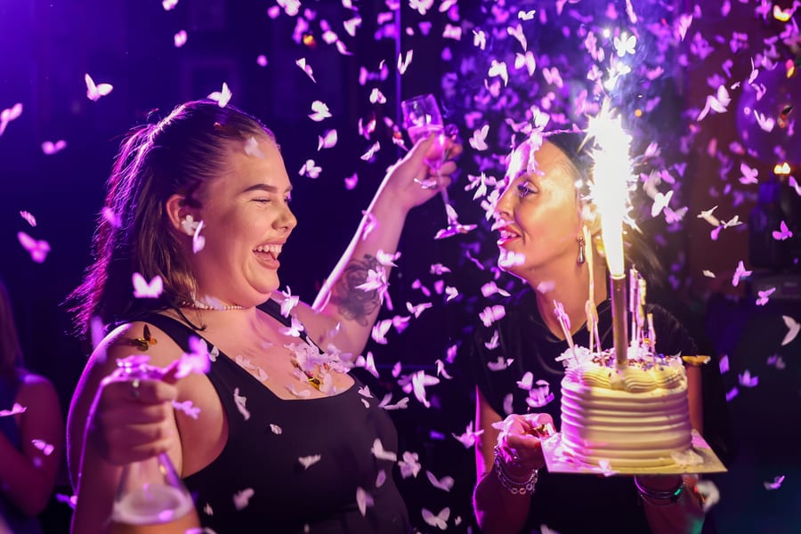 Women celebrating with confetti and cake