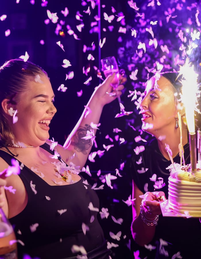 Women celebrating with confetti and cake