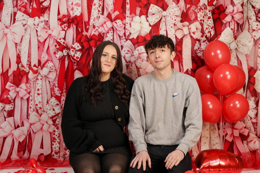 Couple posing — Valentine's Day decorated backdrop
