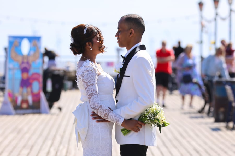 Bride and groom exchanging vows on boardwalk